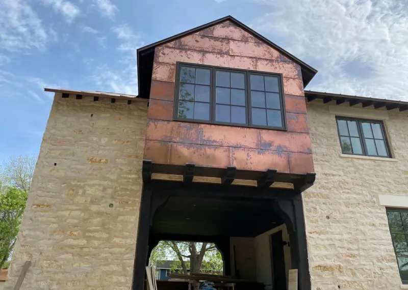 Copper metal panel facade on a stone building for Skylight Installation in Lakeland Village