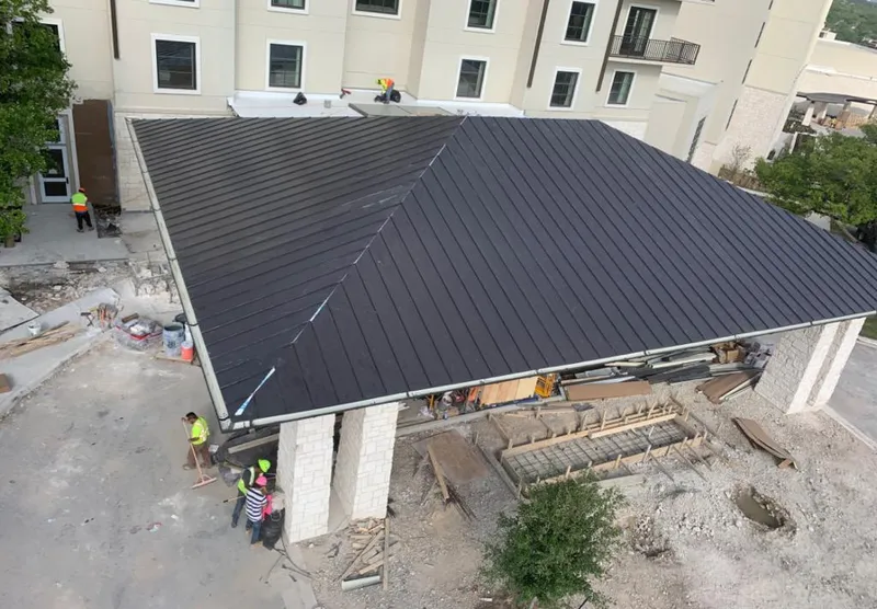 Metal roofing installation team working on a commercial building in Lakeland Village